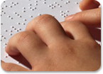 Photo of hands reading braille