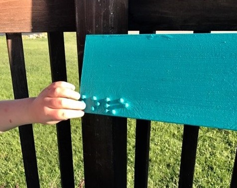 Liam feeling the word "love" in braille on the new bench