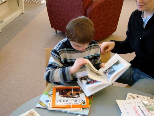 A young boy examines a book