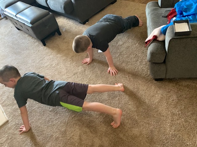 Two boys doing push-ups in the living room