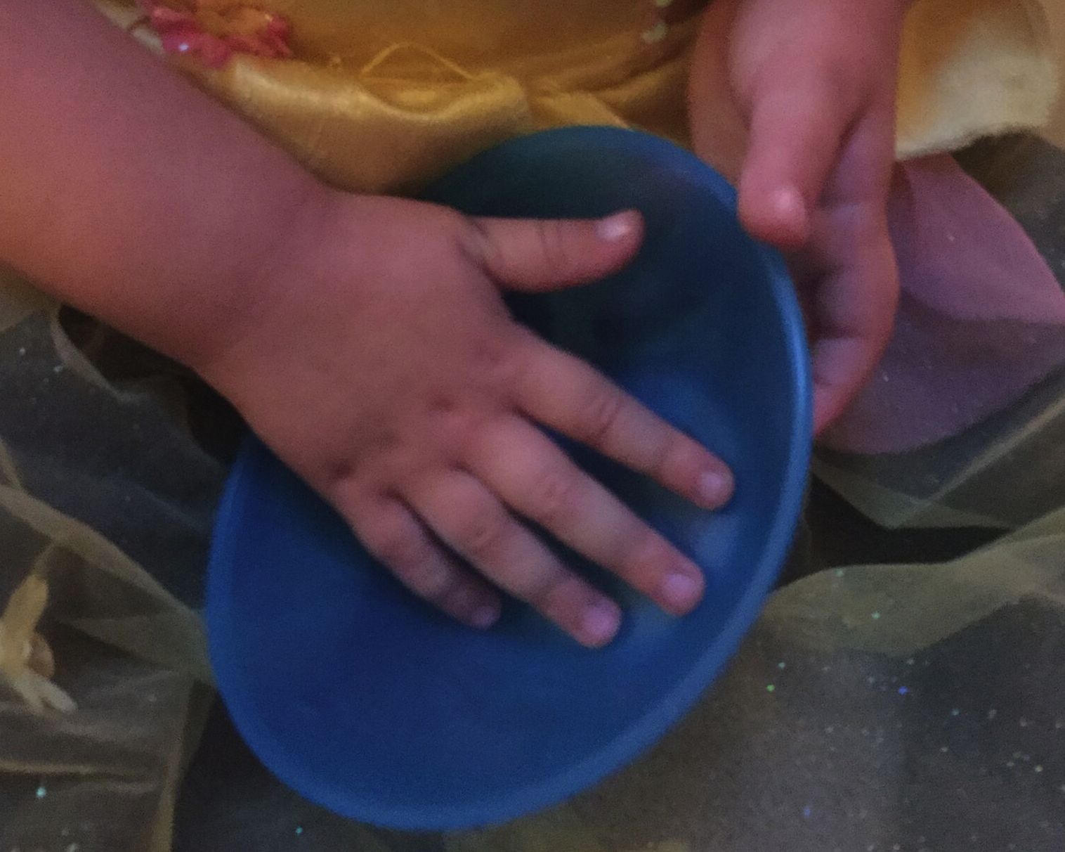 A child's hands explore a bowl.
