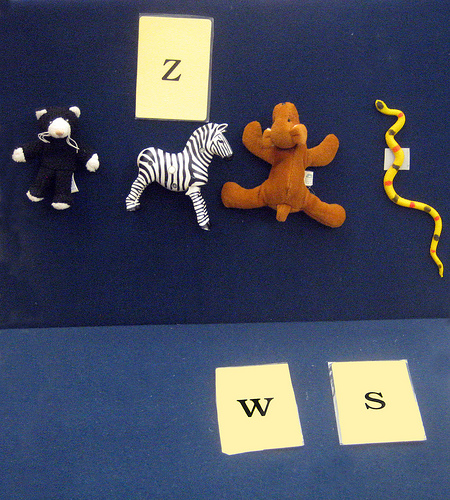 Photo of a veltex board with small stuffed animals and letter cards attached.