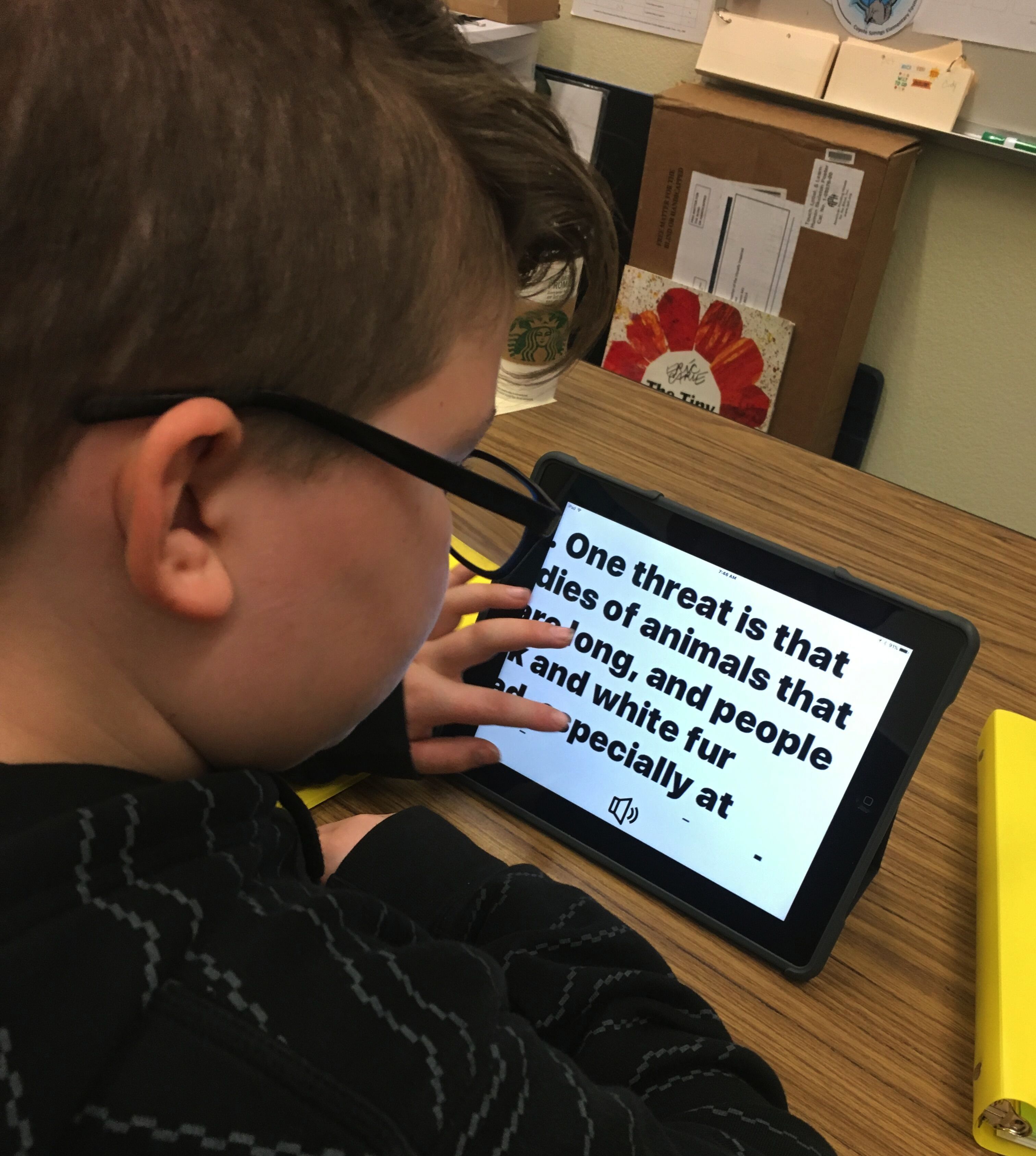 A boy with enlarged print on an iPad