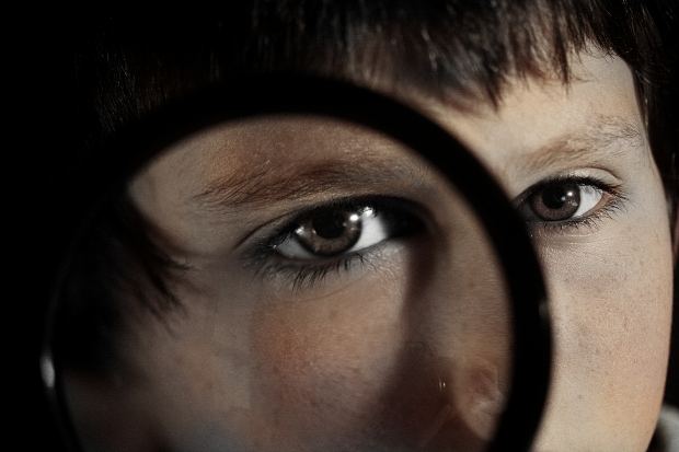 Child looking through magnifying glass