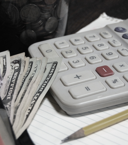 calculator dollar bills coins notepad and a pencil