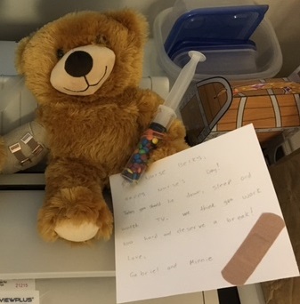 a teddy bear holding a note to nurse in braille