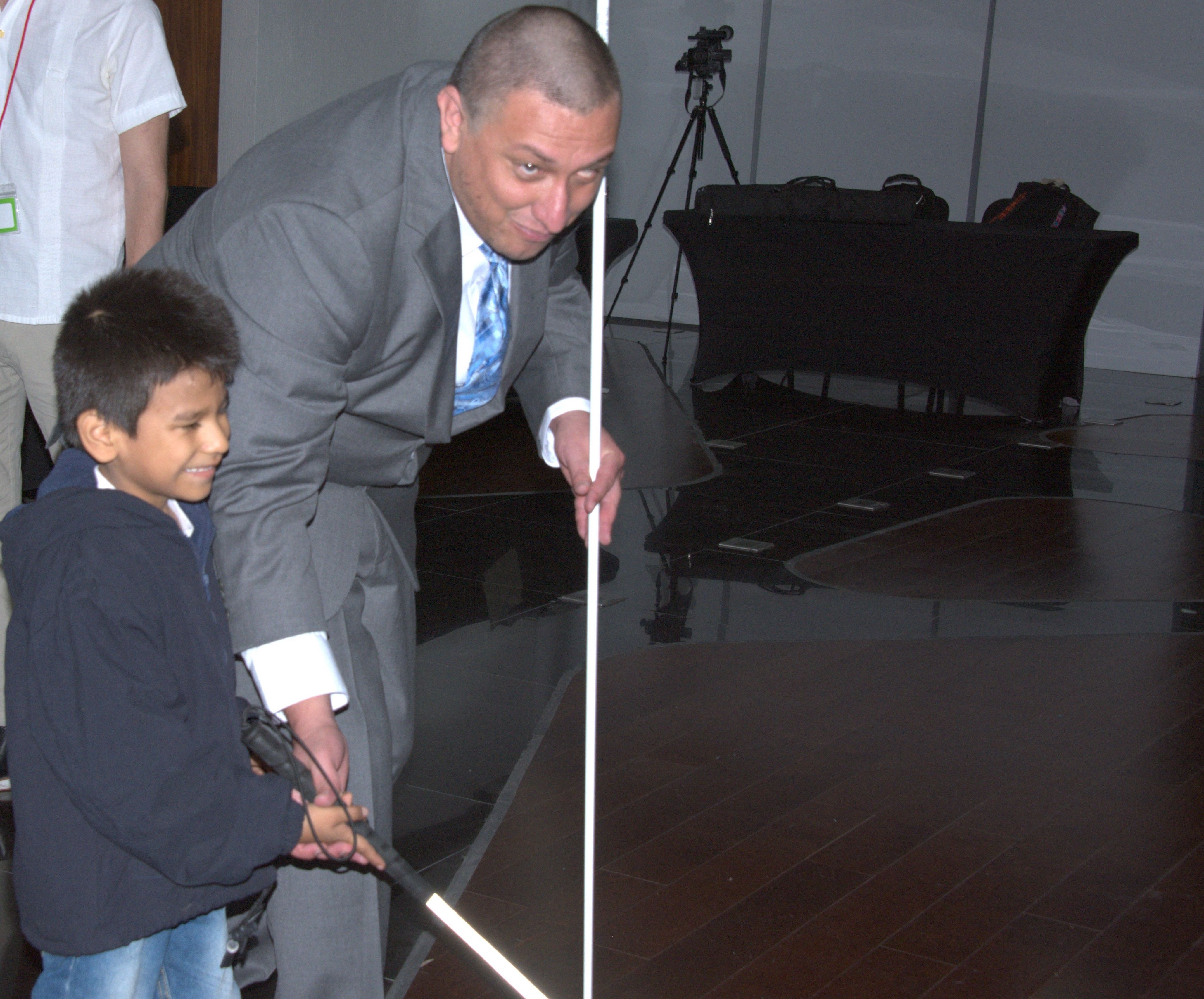 An O&M instructor shows a boy how to hold a cane