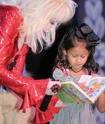 Image of Dolly Parton reading a book with a young girl