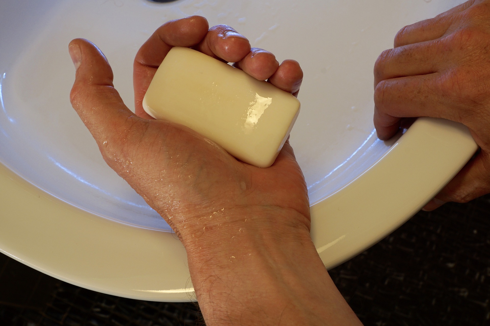 a person washing their hands with a bar of soap