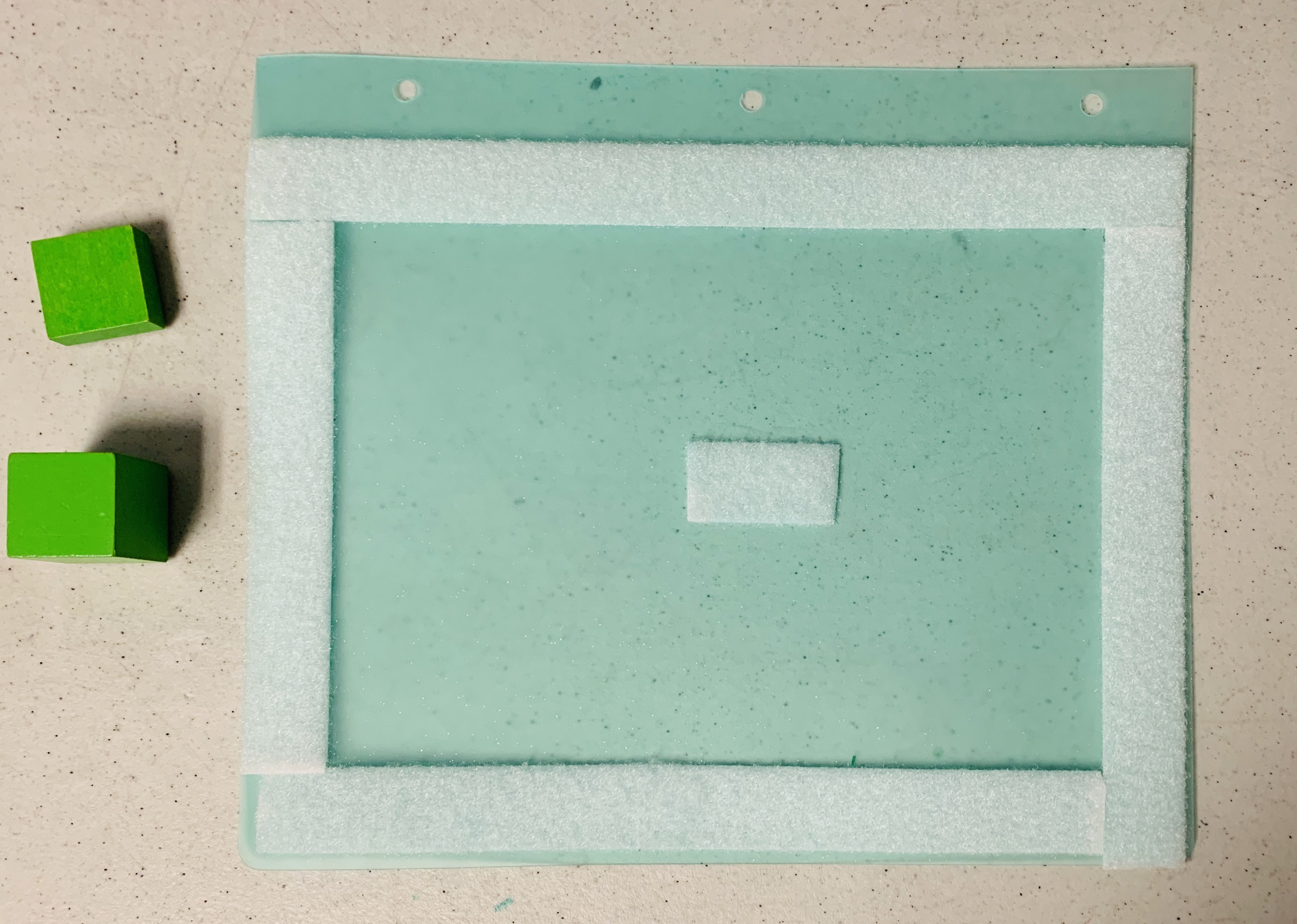 Velcro around perimeter of paper with two square wooden blocks on the left side.