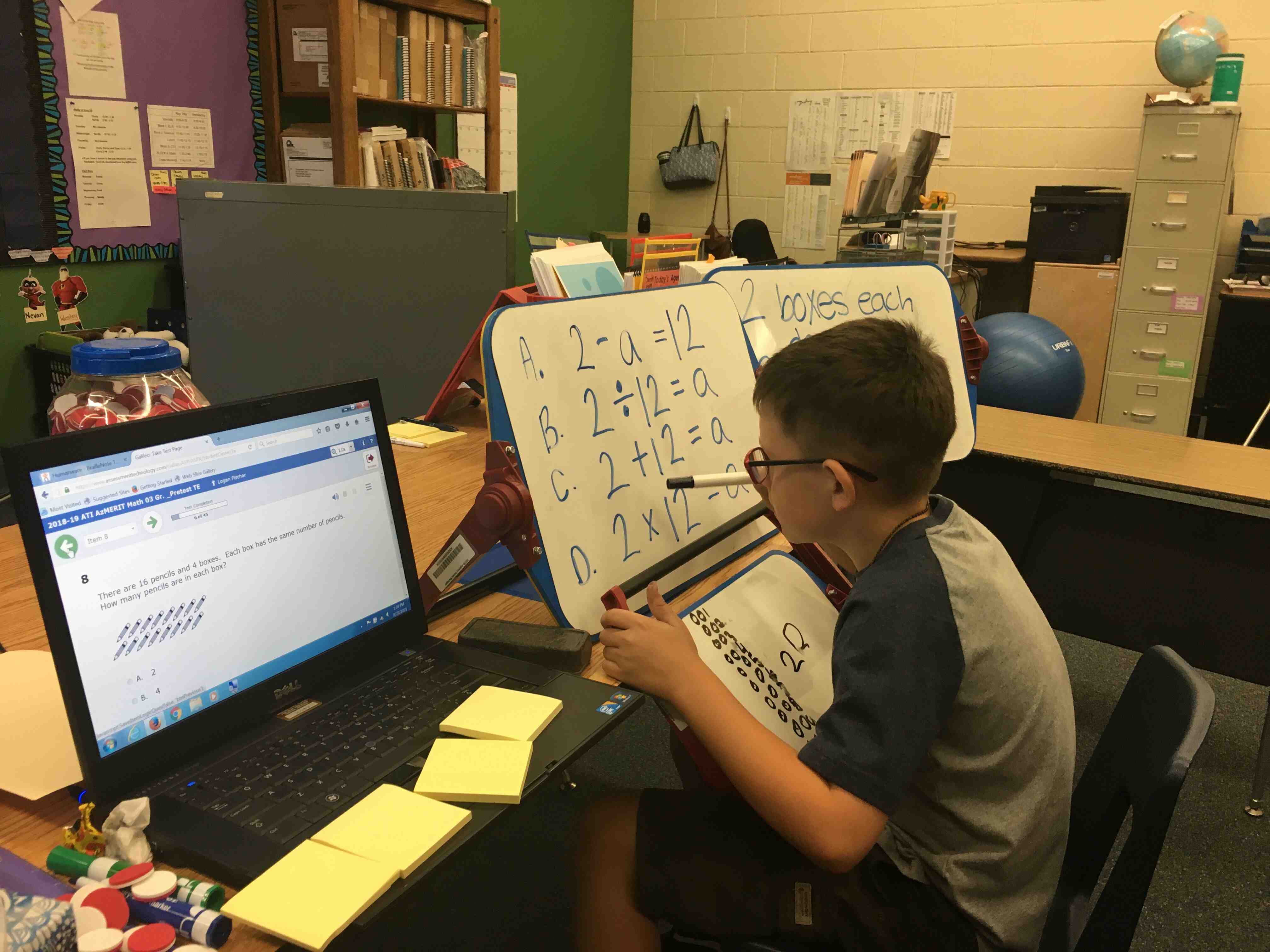 A boy uses a white board and a computer screen