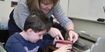 A teacher shows a student how to use an abacus