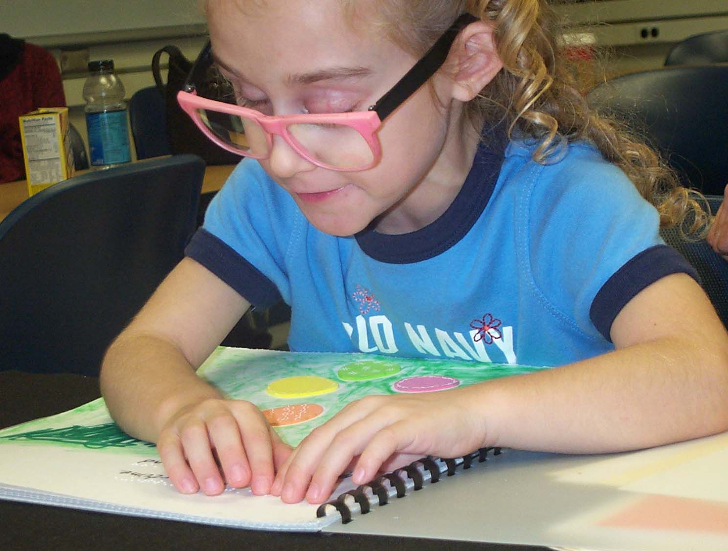 A girl reading a braille book