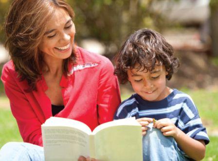 A woman reads a book with a young boy.
