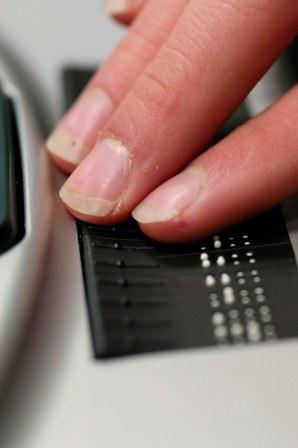 Fingers reading a line of refreshable braille