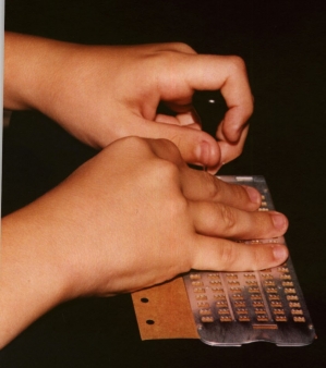 hands using a slate and stylus