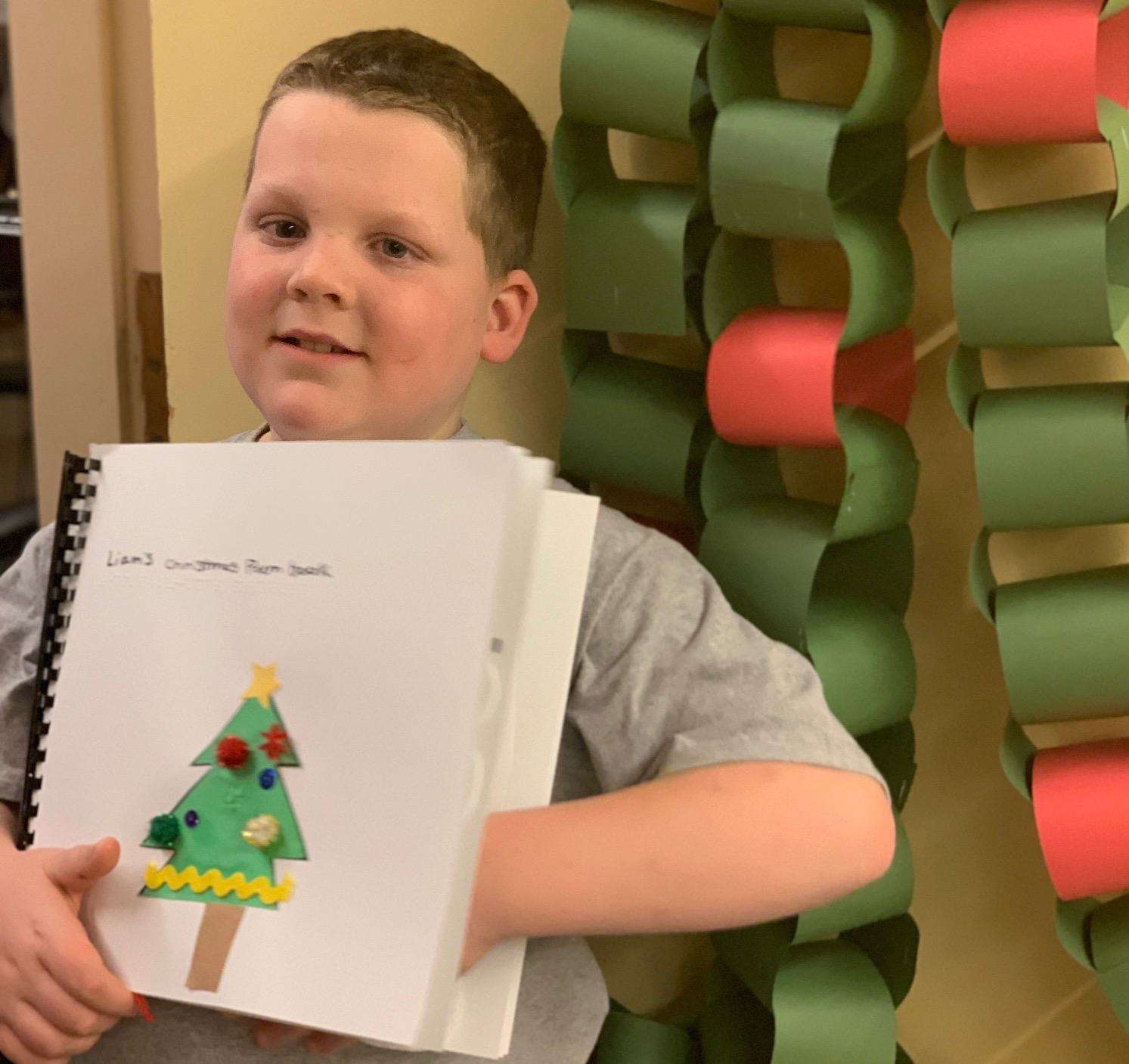 Boy holding braille book of Christmas poems